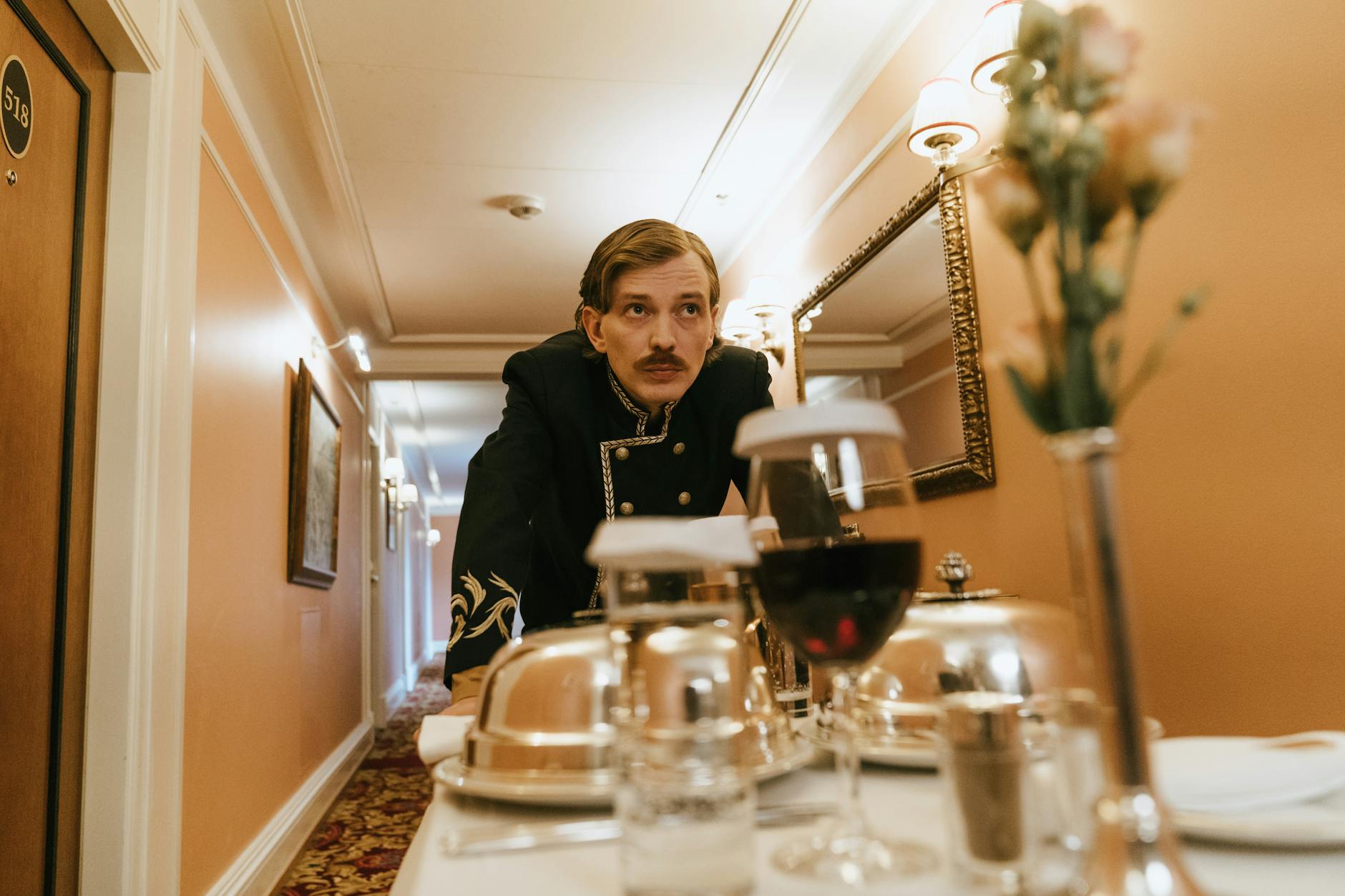 Pracownik hotelu w mundurze niesie room service korytarzem w Szanghaju