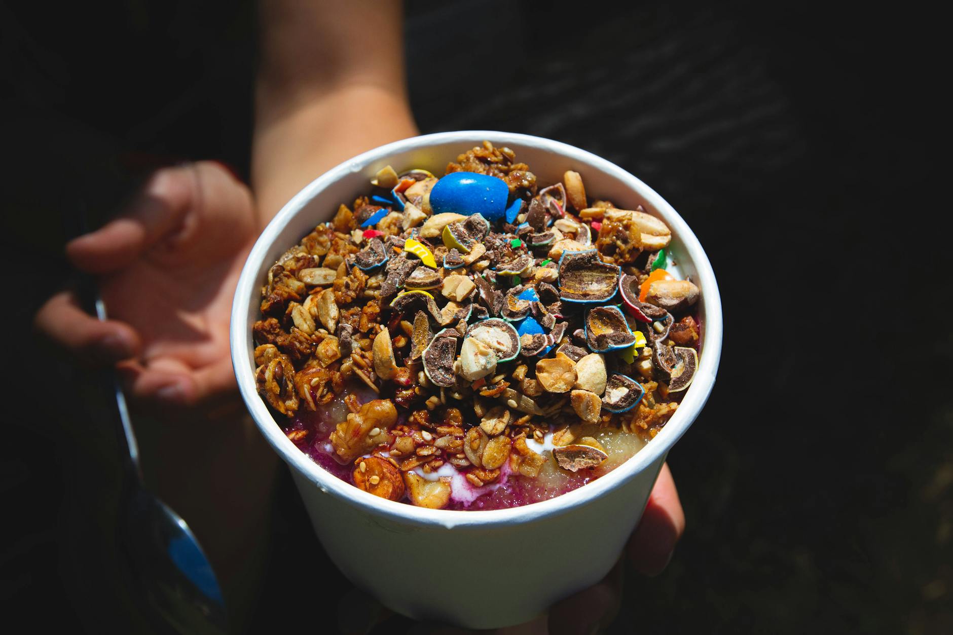Smoothie bowl z granolą i kawałkami czekolady na białym talerzu